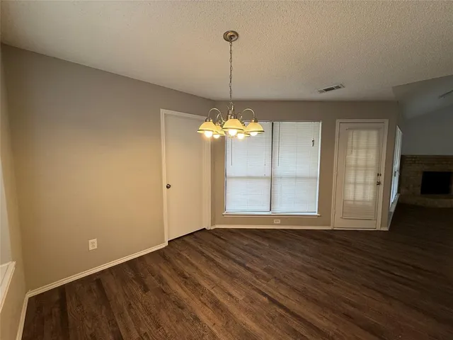 a view of a room with wooden floor chandelier and window