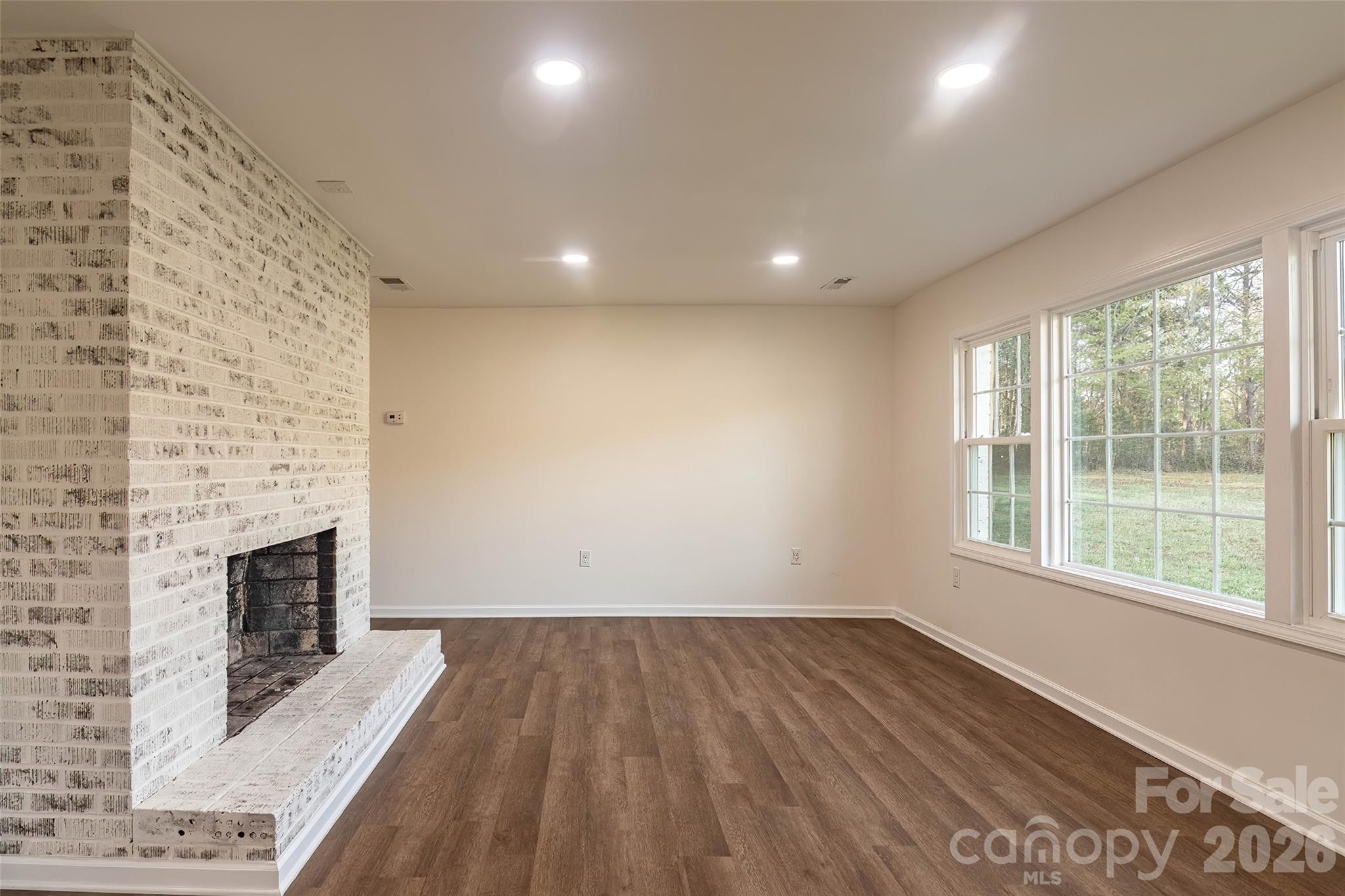 281 Jack McKinney Road Forest City, NC 28043 - Photo 11 of 37 an empty room with wooden floor and fireplace
