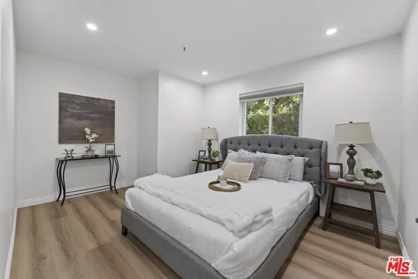 a large bedroom with a bed and a wooden floor