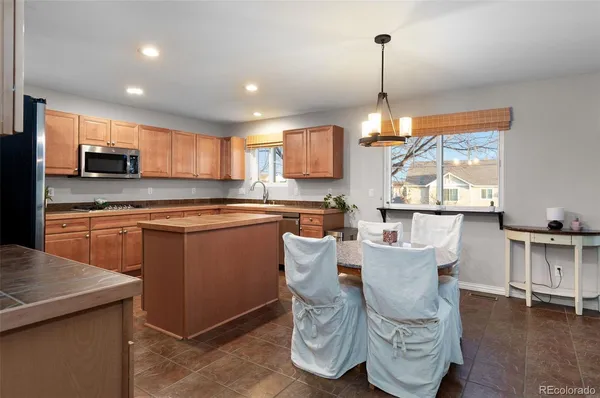 a kitchen with kitchen island granite countertop wooden floors and white cabinets