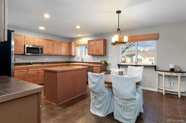 a kitchen with kitchen island granite countertop wooden floors and white cabinets