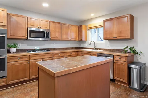 a kitchen with stainless steel appliances granite countertop a sink stove and microwave