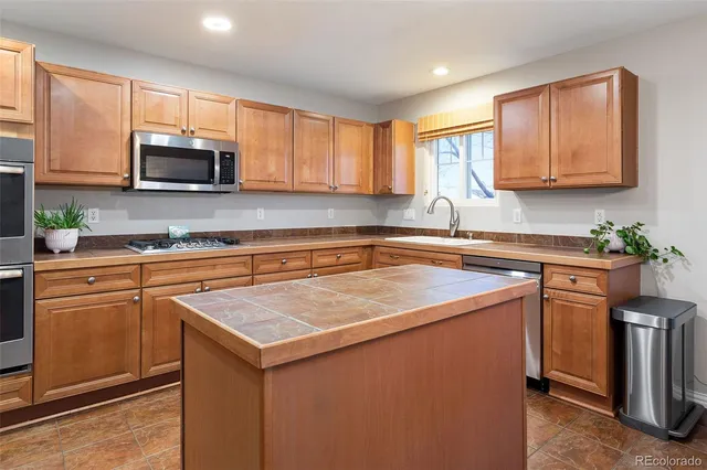 a kitchen with stainless steel appliances granite countertop a sink stove and microwave