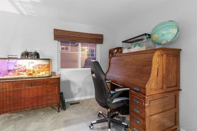 a view of a workspace with furniture and a window