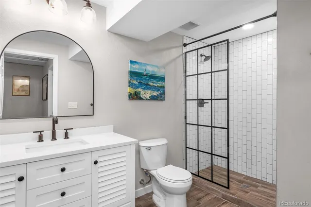 a bathroom with a toilet a sink and mirror