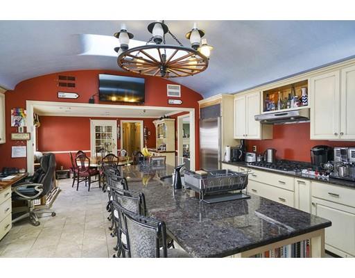 930 Main Street Hingham, MA 02043 - Photo 4 of 30 a kitchen with stainless steel appliances granite countertop a stove top oven a dining table and chairs with the living room