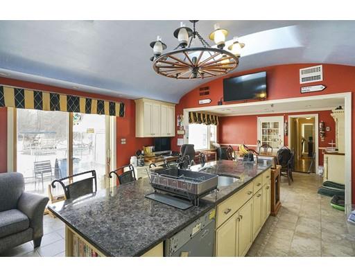 930 Main Street Hingham, MA 02043 - Photo 5 of 30 a kitchen with stainless steel appliances granite countertop a sink dishwasher a living room with couches chairs and next to a window