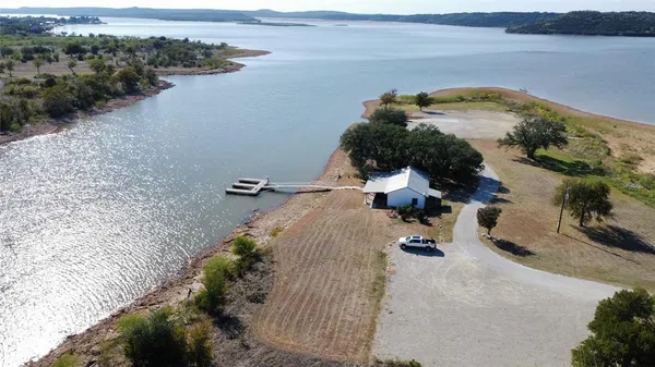 an aerial view of a house with outdoor space and lake view