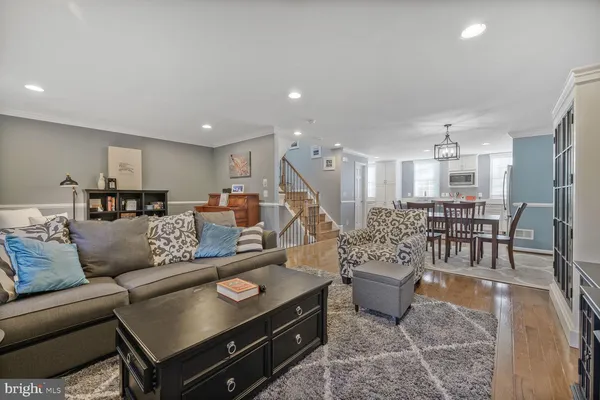 a living room with furniture and a dining table with kitchen view