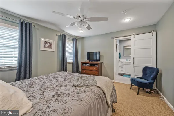 a spacious bedroom with a bed and a chair