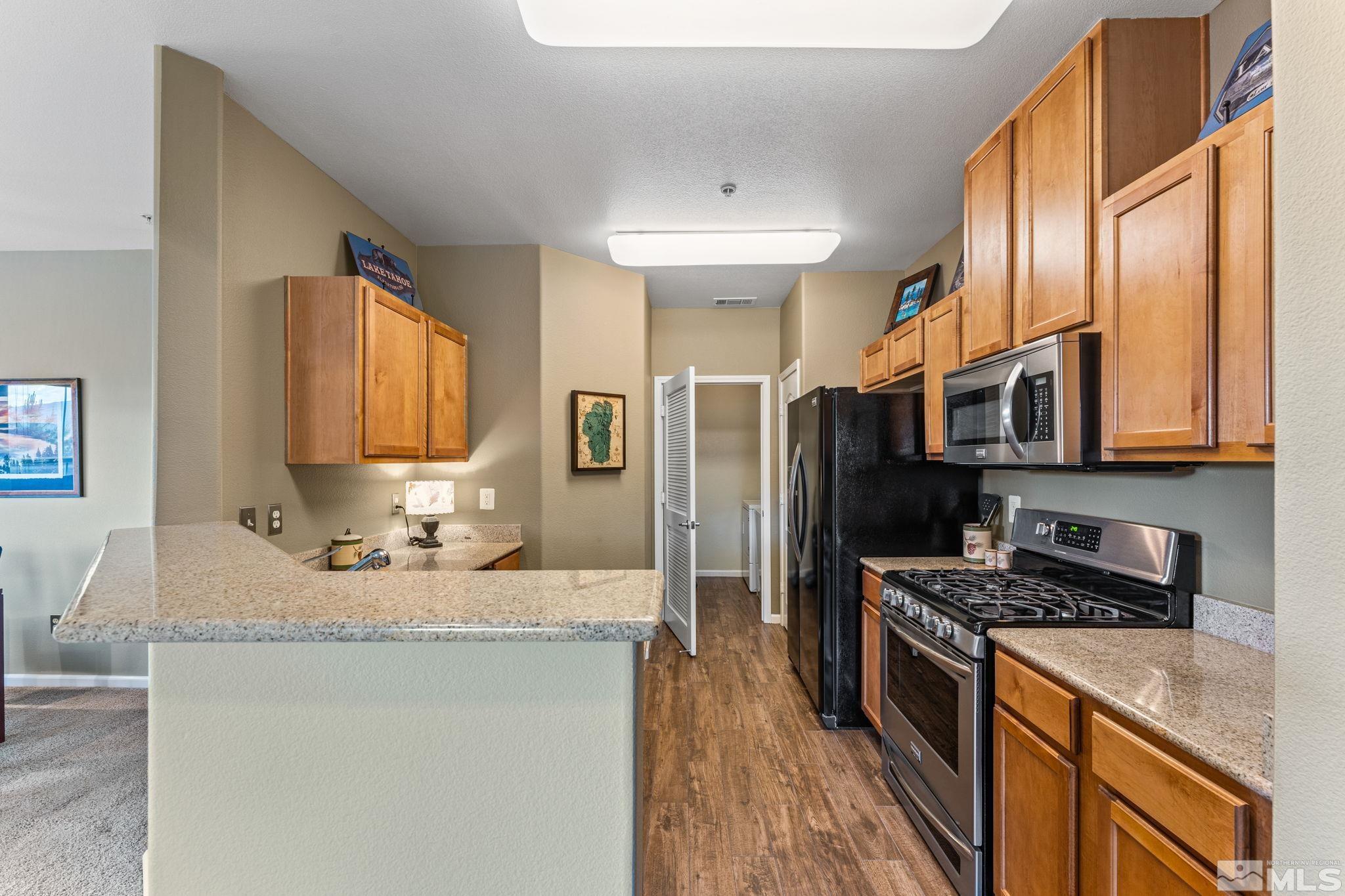 9050 Double R Boulevard, Unit 921 Reno, NV 89521 - Photo 18 of 39 a kitchen with stainless steel appliances granite countertop a sink stove and refrigerator