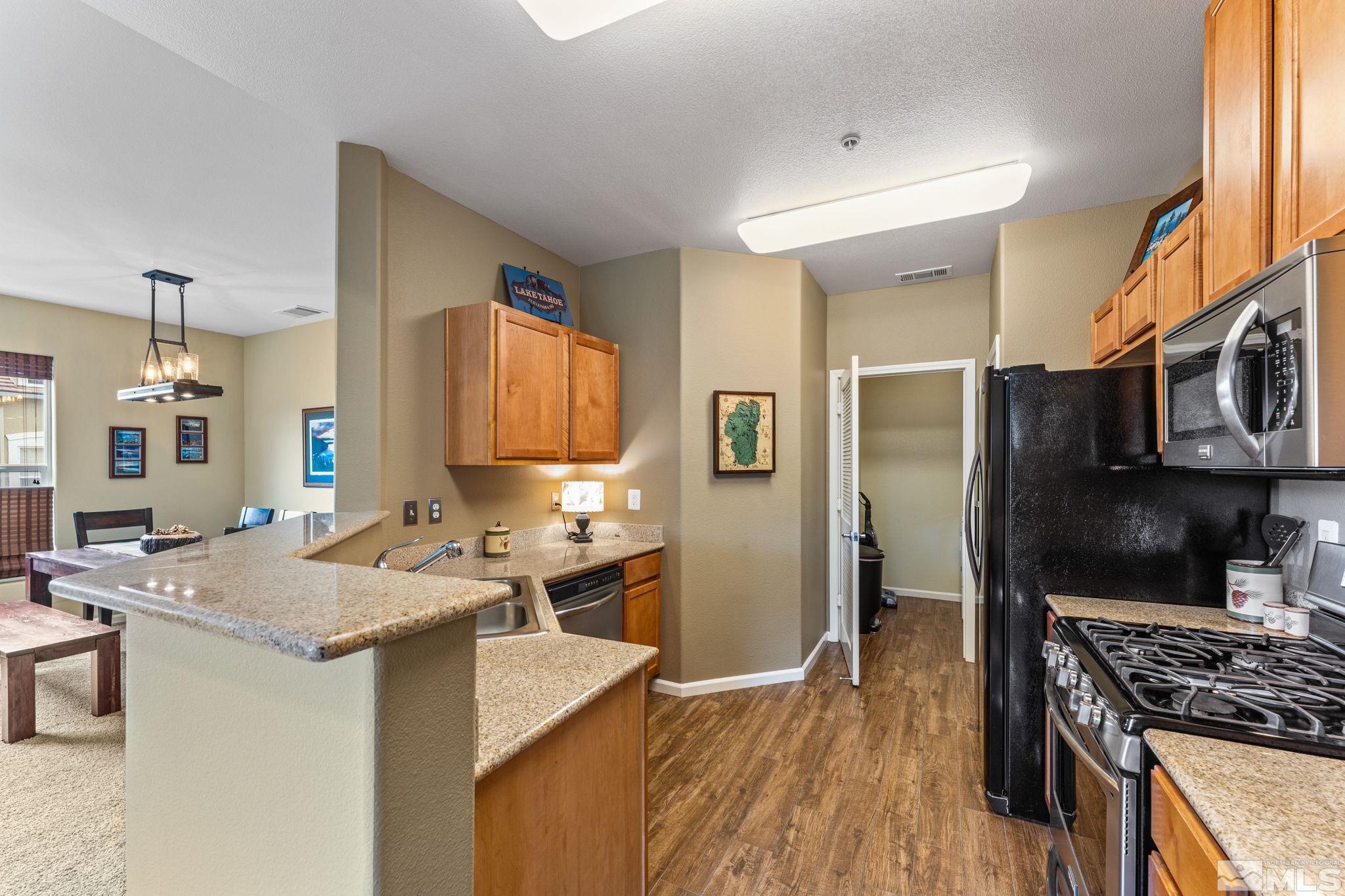 9050 Double R Boulevard, Unit 921 Reno, NV 89521 - Photo 19 of 39 a kitchen with stainless steel appliances granite countertop a sink stove and refrigerator