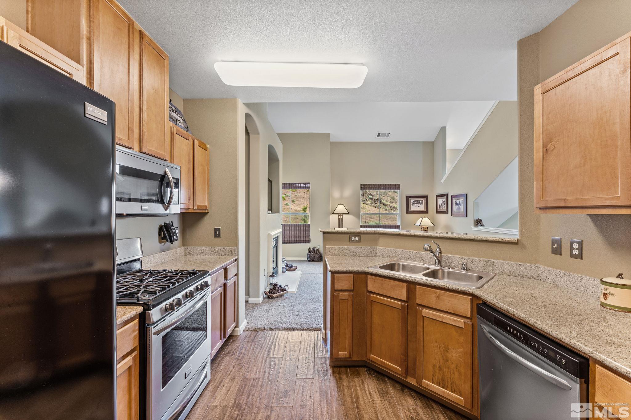 9050 Double R Boulevard, Unit 921 Reno, NV 89521 - Photo 20 of 39 a kitchen with stainless steel appliances granite countertop a sink stove and refrigerator