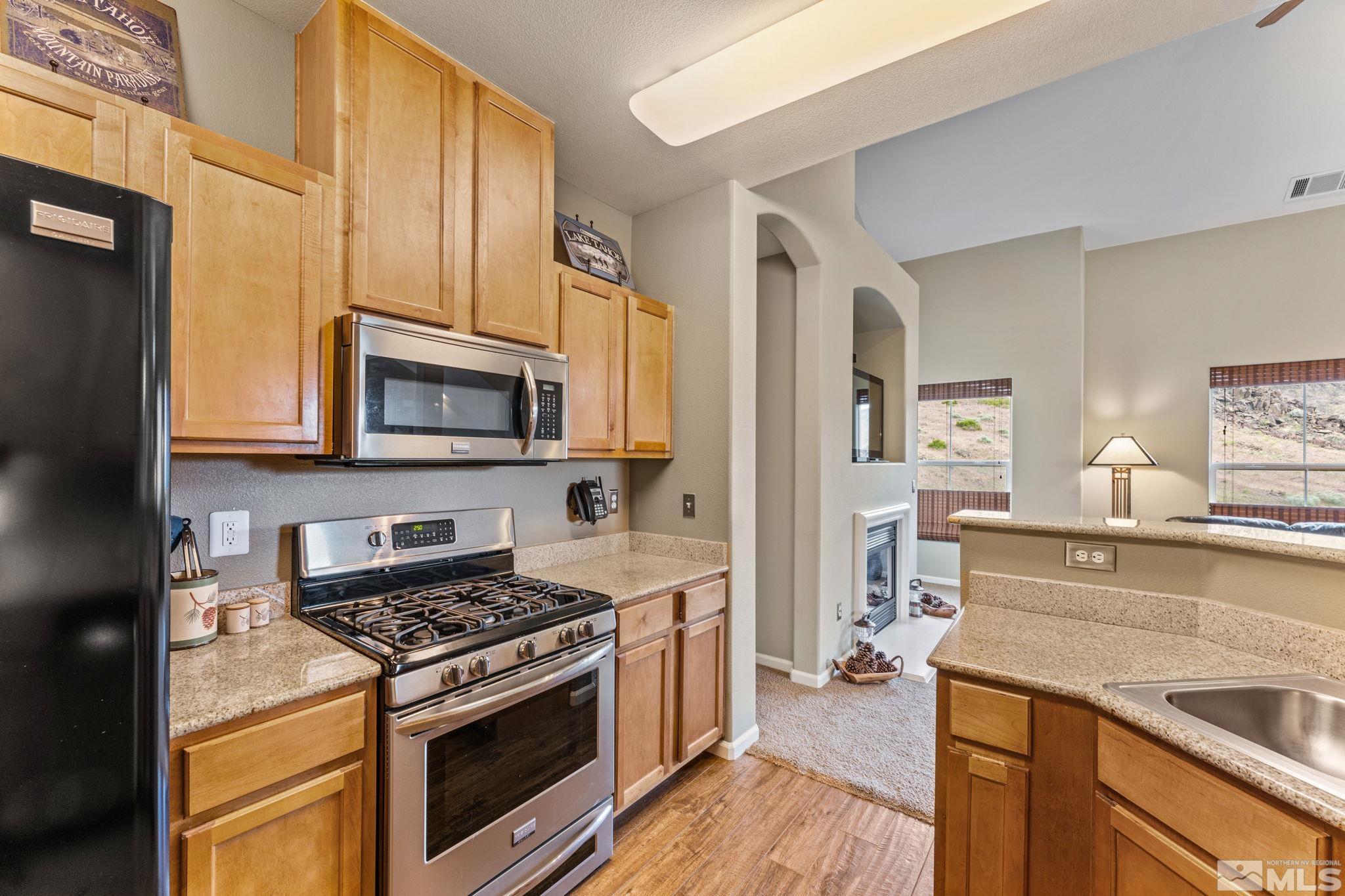 9050 Double R Boulevard, Unit 921 Reno, NV 89521 - Photo 21 of 39 a kitchen with stainless steel appliances white cabinets and a stove top oven