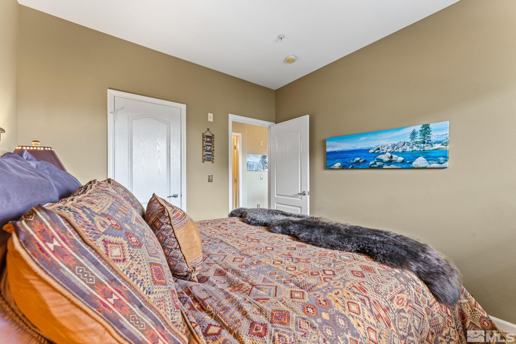 9050 Double R Boulevard, Unit 921 Reno, NV 89521 - Photo 27 of 39 a bedroom with a bed and a painting on the wall