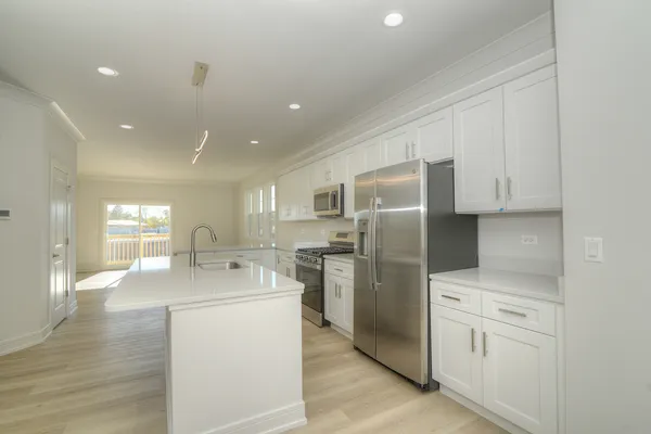 a kitchen with stainless steel appliances a refrigerator sink and cabinets