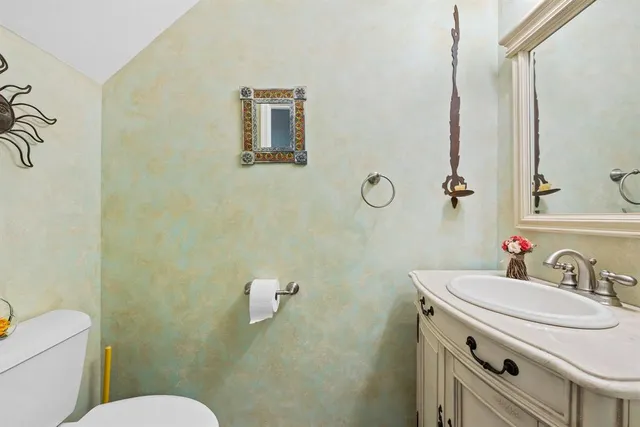 a bathroom with a toilet sink a mirror and vanity