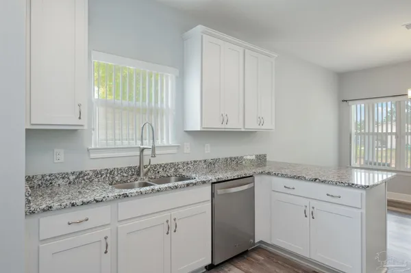 a kitchen with granite countertop white cabinets and white appliances