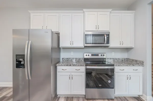 a kitchen with white cabinets and stainless steel appliances