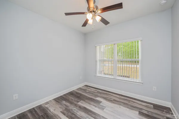 an empty room with a window and a fan