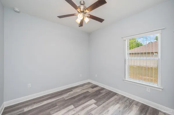 an empty room with a window and a fan