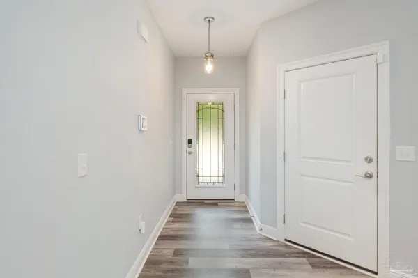 a view of a hallway with wooden floor and a chandelier