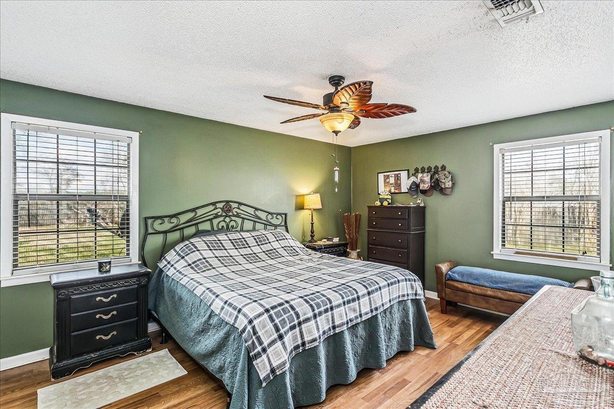 295 Columbus Circle Brewton, AL 36426 - Photo 15 of 32 a bedroom with a bed and a dresser next to a window