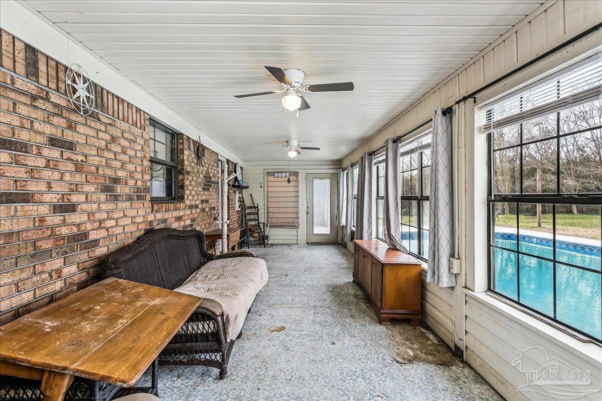 295 Columbus Circle Brewton, AL 36426 - Photo 24 of 32 a living room with furniture a fireplace and a floor to ceiling window