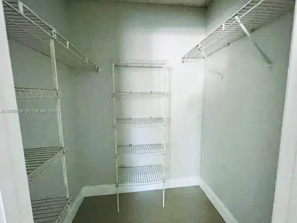 a view of walk in closet with empty racks