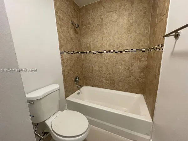 a white toilet sitting next to a bath tub