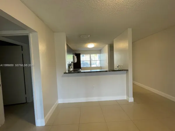 a view of a kitchen with a sink and a refrigerator