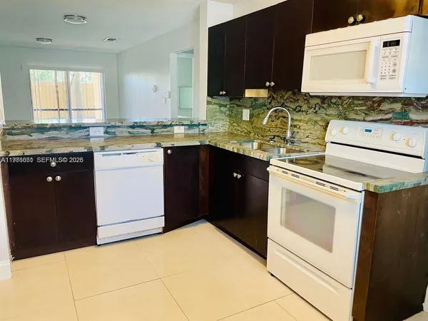 a kitchen with a stove sink and cabinets