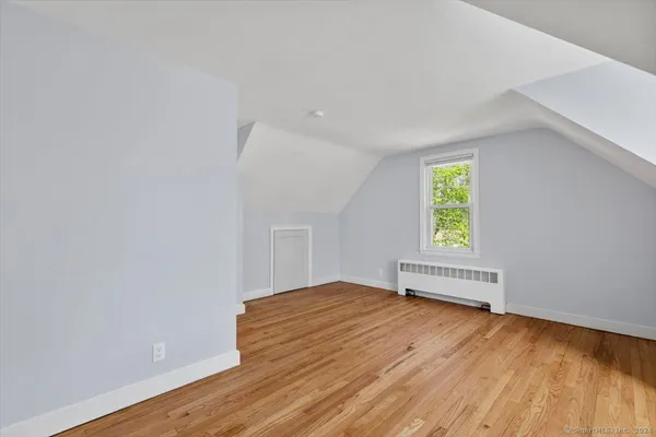 an empty room with a window and wooden floor