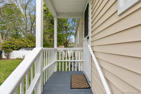 a balcony with wooden floor in front of a house