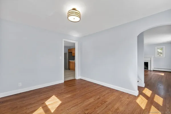 an empty room with wooden floor and window