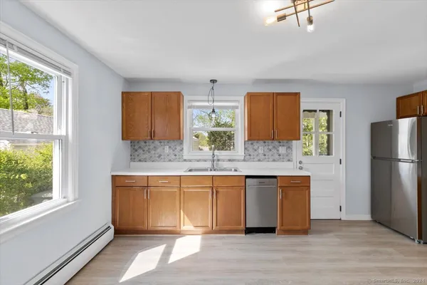 a large kitchen with stainless steel appliances granite countertop a refrigerator and a sink