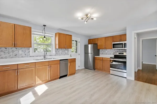 a kitchen with stainless steel appliances a refrigerator sink and microwave