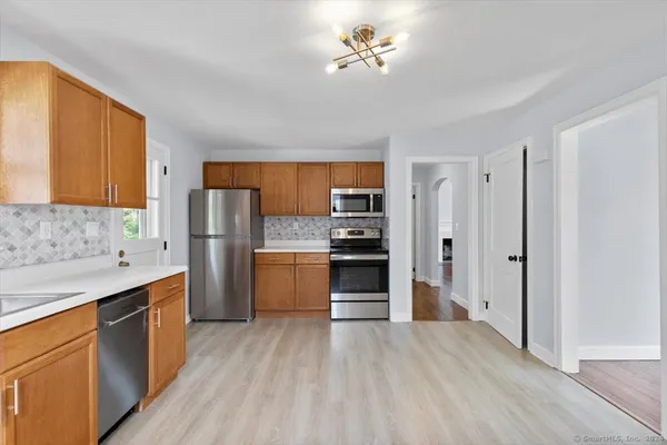 a kitchen with stainless steel appliances a refrigerator and a stove top oven