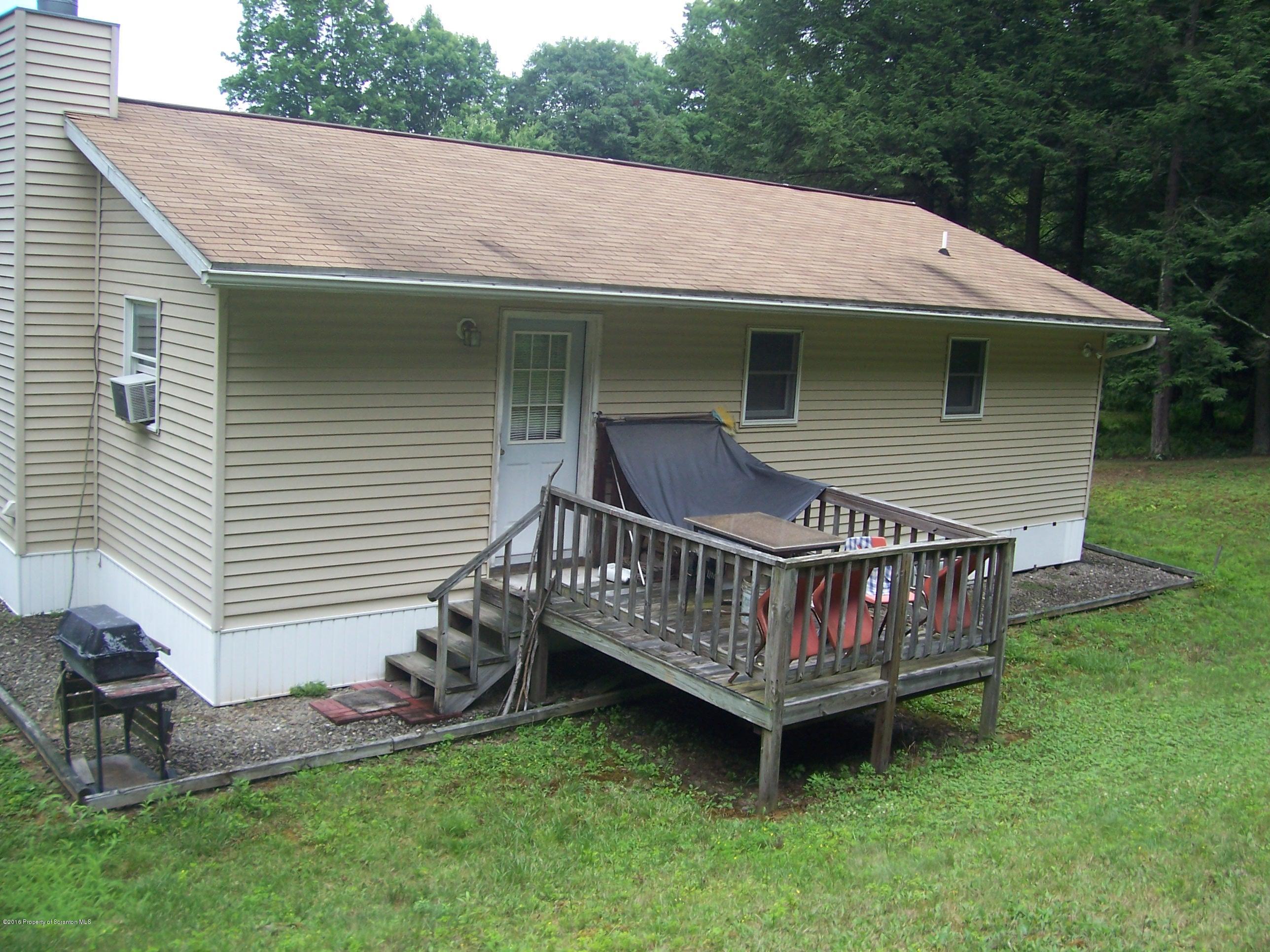 470 Blue Stone Road Meshoppen, PA 18630 - Photo 3 of 13 a front view of a house with garden and deck