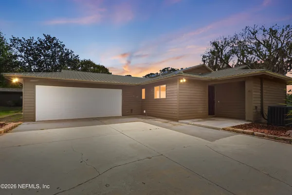 a view of a kitchen with a stove wooden cabinets and wooden floor