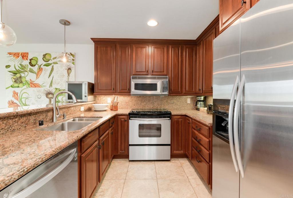 935 Genter Street, Unit 212 La Jolla, CA 92037 - Photo 12 of 23 a kitchen with stainless steel appliances granite countertop wooden cabinets a sink and a stove