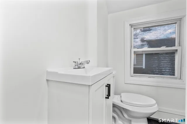 a bathroom with a sink mirror and toilet