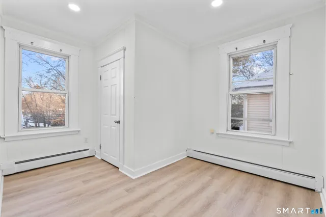 an empty room with wooden floor and window