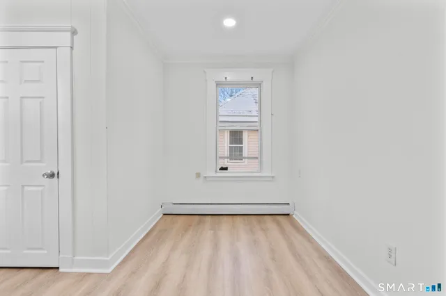 a view of a room with wooden floor and window