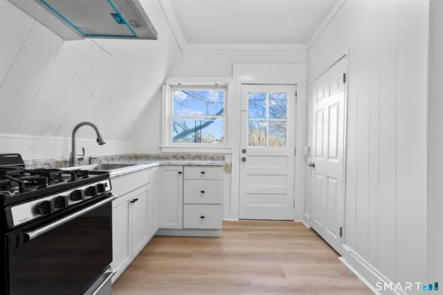 a kitchen with granite countertop a stove and a sink
