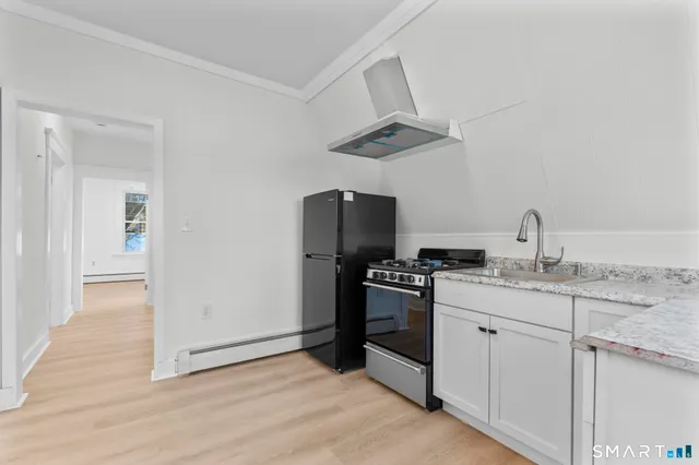 a kitchen with stainless steel appliances granite countertop a sink a stove and a refrigerator