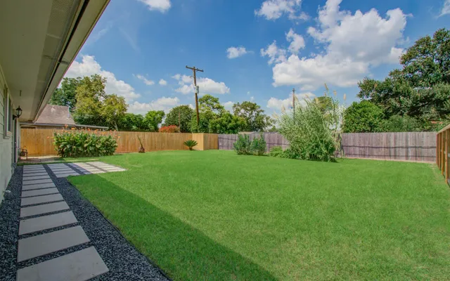 a view of yard with swimming pool and green space