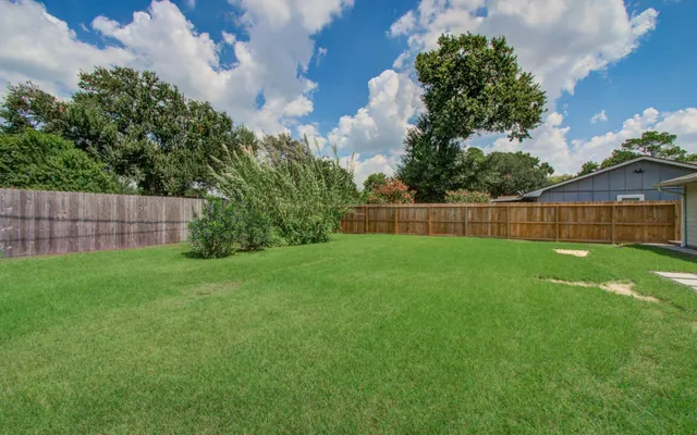 a view of yard with green space and wooden fence