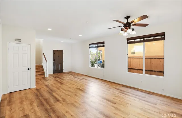a view of empty room with window and wooden floor