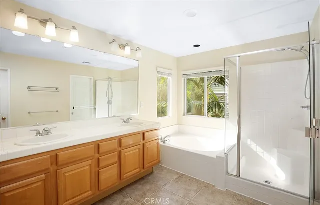 a spacious bathroom with a tub sink shower and mirror